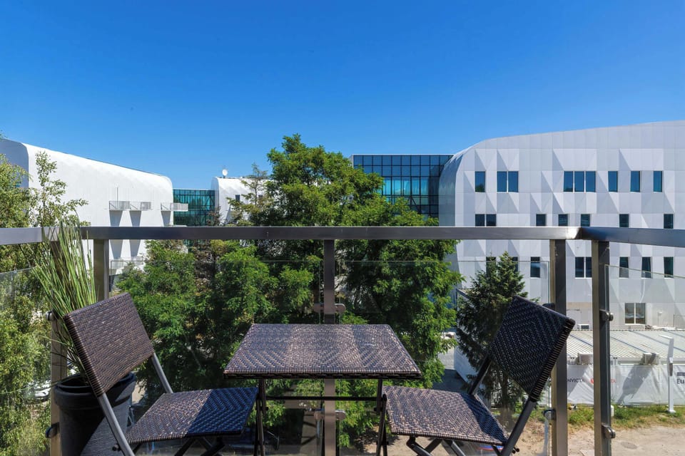 Outdoor seating area perfect for relaxing or dining al fresco, surrounded by greenery and modern architecture.