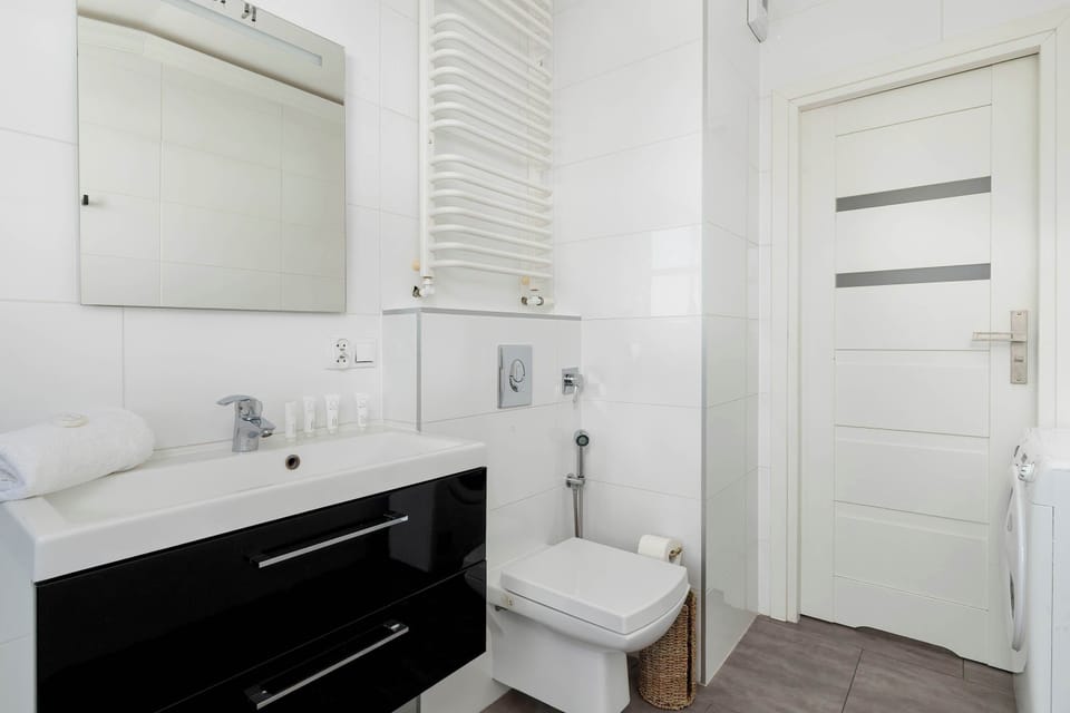 Elegant bathroom with a shower, toilet, and sleek black-and-white decor.