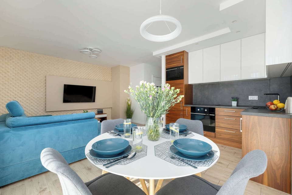 Spacious, bright living room with a round table and comfortable chairs.