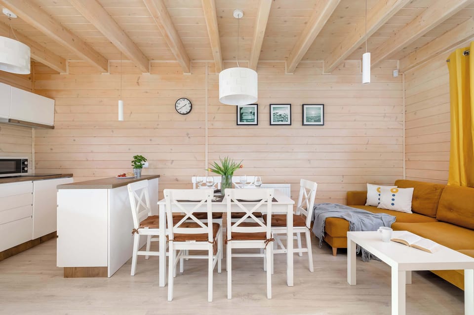 The dining area with a white table and chairs blends harmoniously with the rest of the room.