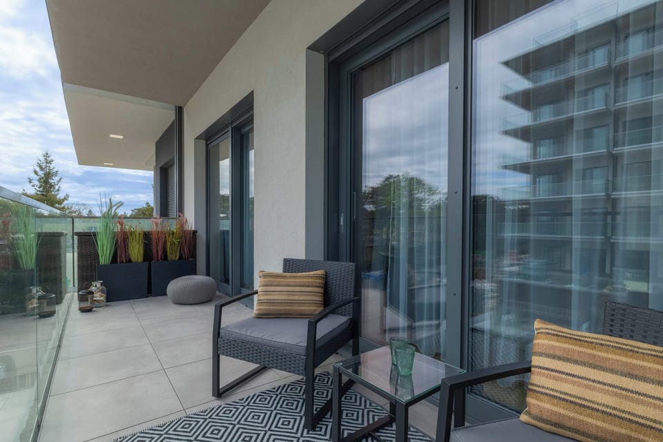 A cozy outdoor balcony with comfortable seating offers a relaxing view of the surroundings.