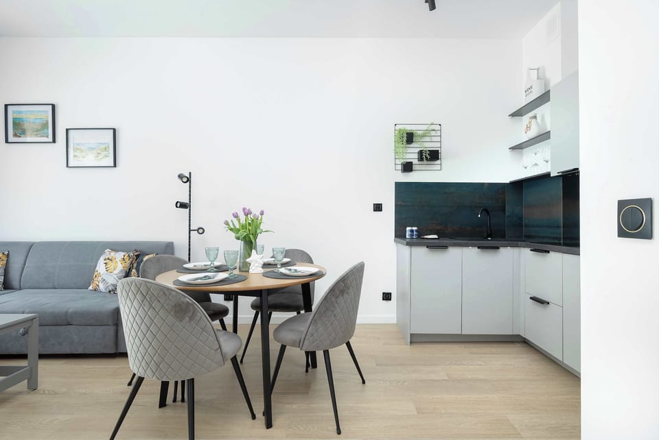 A stylish dining room with a round table for four, decorated with modern decorations, creating a pleasant atmosphere for meals.