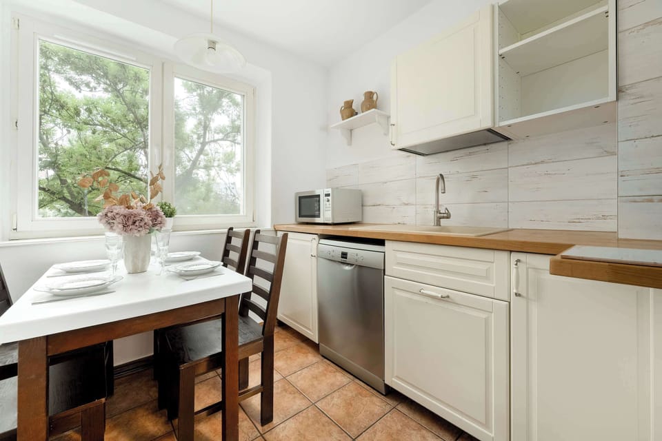 A compact yet functional kitchen with white cabinets and all necessary appliances. Great for preparing everyday meals.