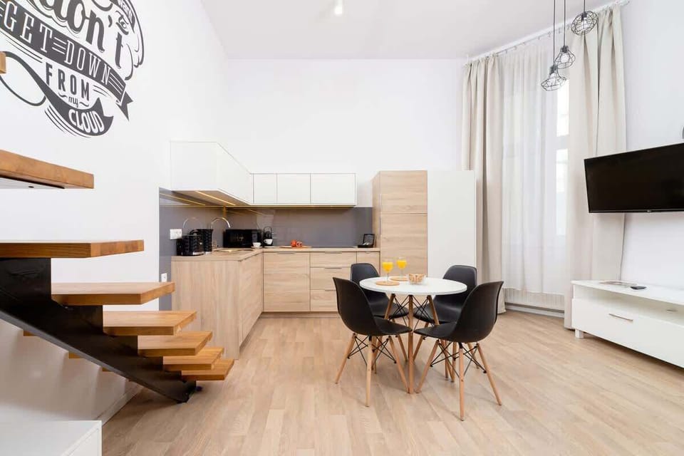 A compact yet stylish kitchen corner with a coffee machine, fruit, and modern lighting.