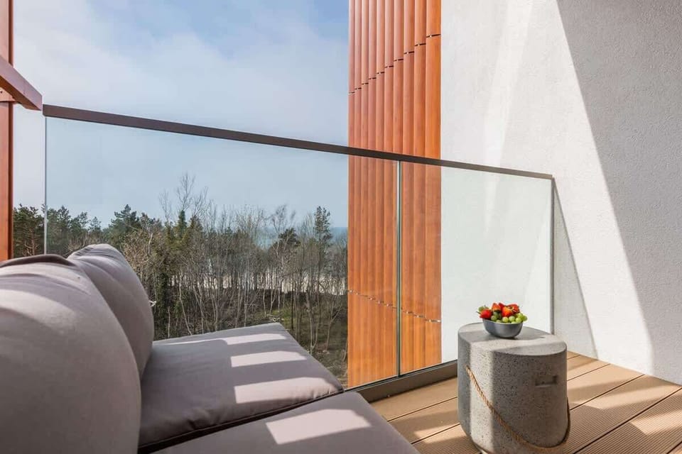 An outdoor seating arrangement on the balcony, with a table displaying a bowl of fresh fruit.