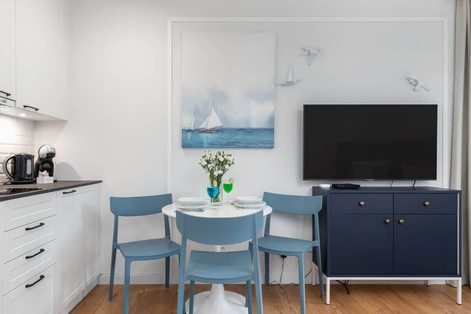 A fully equipped kitchen with white cabinetry, a tiled backsplash, and modern appliances.