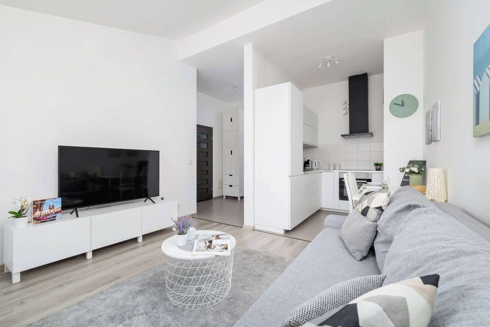A wider view of the living room, showing its open-plan layout connected to the dining area. Comfortable seating and soft lighting make it a perfect spot for unwinding.
