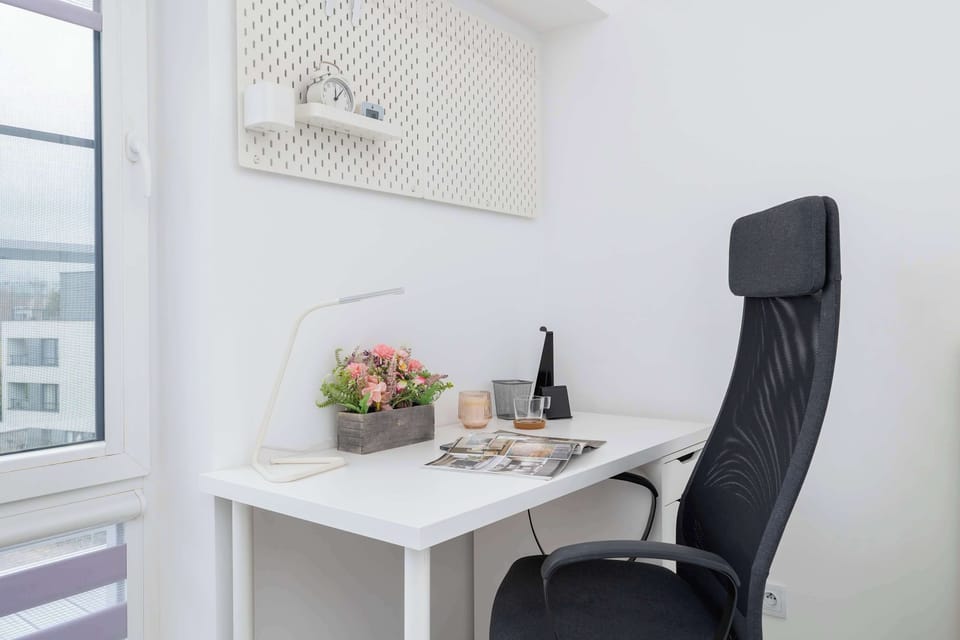 A cozy workspace with a stylish black chair and a compact desk. Perfect for remote work or quiet reading.