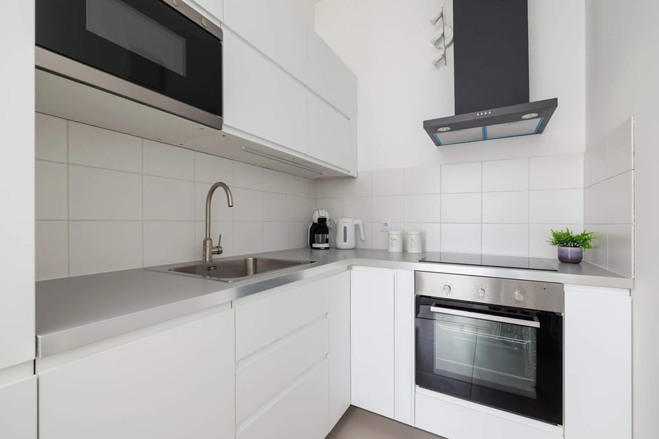 Another view of the kitchen, focusing on the sink area with minimalist design elements. The black and white color scheme enhances the contemporary look.