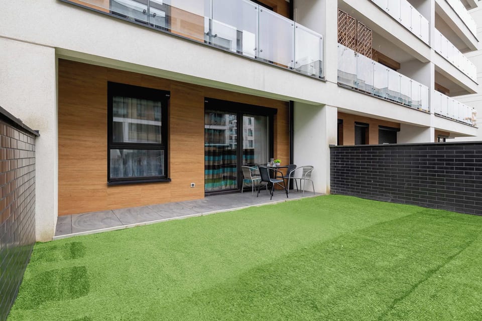 A green terrace with a well-maintained lawn and a view of the modern building. A perfect outdoor spot to relax.