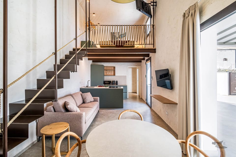Modern open-plan living with high ceilings, a cozy sofa bed, and a stylish kitchen.