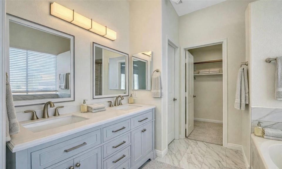 In suite master bathroom with walk-in shower, dual vanity and soaking tub