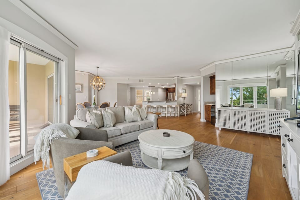 Plush seating arranged around a central coffee table and plenty of natural light streaming in from the sliding doors.