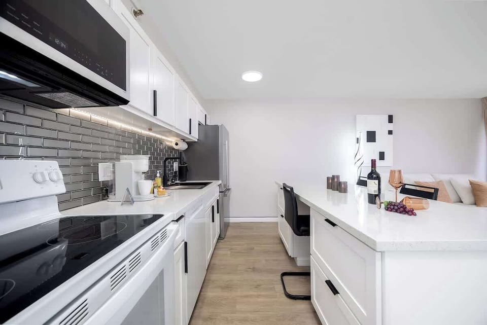 Cook with ease in our pristine kitchen, featuring a full-sized refrigerator, microwave, oven, and stovetop for all your culinary adventures.