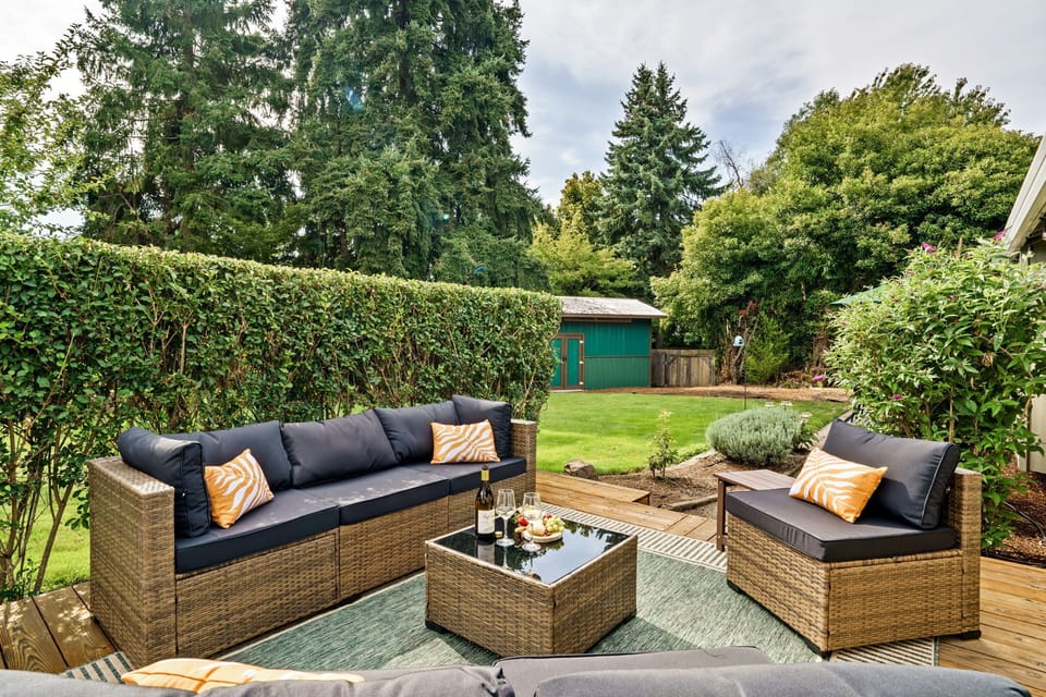 Outdoor patio with comfortable lounge furniture surrounded by lush greenery.