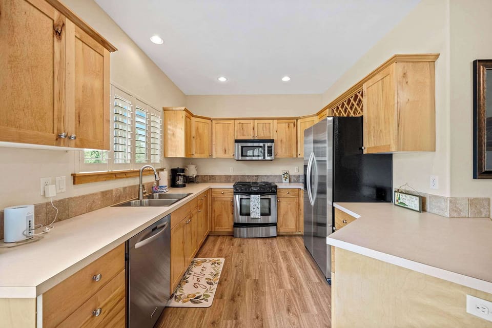Your spacious kitchen features granite counters, stainless appliances, and warm wood cabinetry - perfect for preparing meals and morning coffee together.