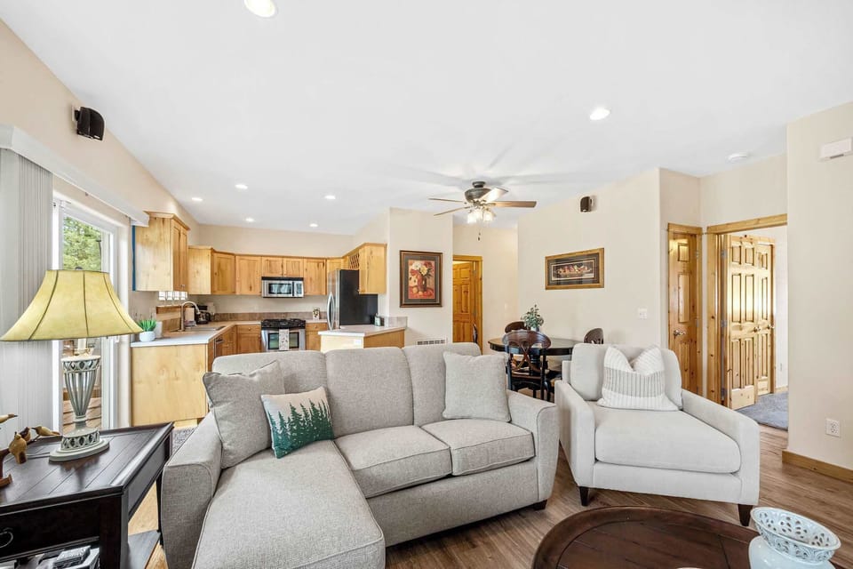 Unwind in this open-concept living space where plush gray seating flows into a fully equipped kitchen, perfect for your home-away-from-home comfort.