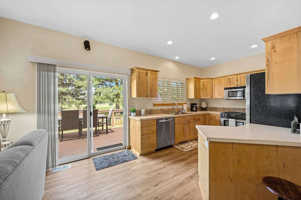 Step into your spacious kitchen where warm wood cabinetry and modern appliances create the perfect space for preparing meals and sharing moments together.