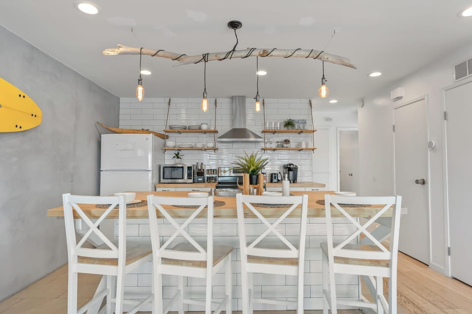 Modern kitchen with barstool seating and stainless steel appliances.