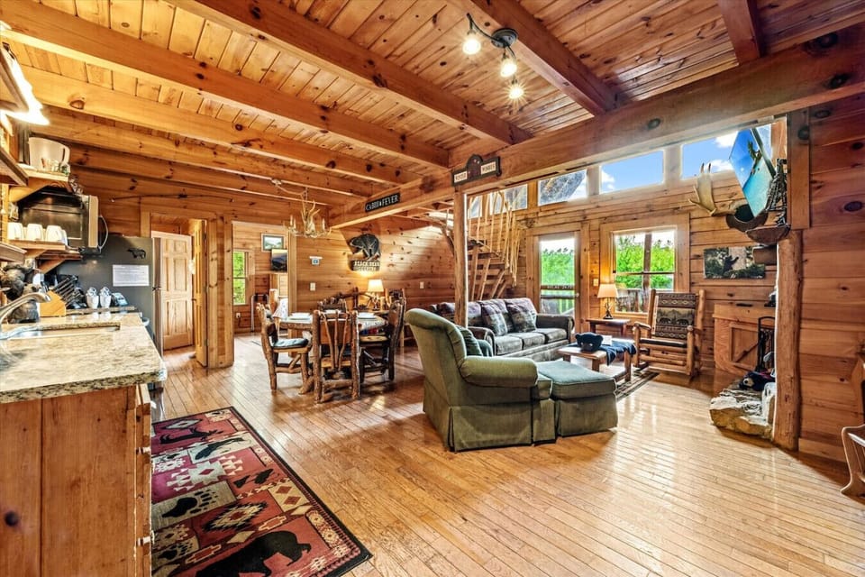 Natural light floods the living area, highlighting the handcrafted log accents and inviting atmosphere of this mountain retreat.