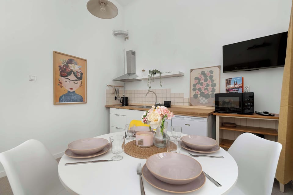 A stylish round dining table set for four, perfect for shared meals or morning coffee.