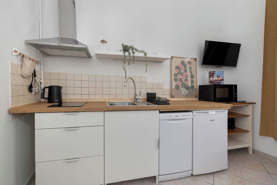 A clean and functional kitchen space with essential appliances and a compact desk area for work or planning.