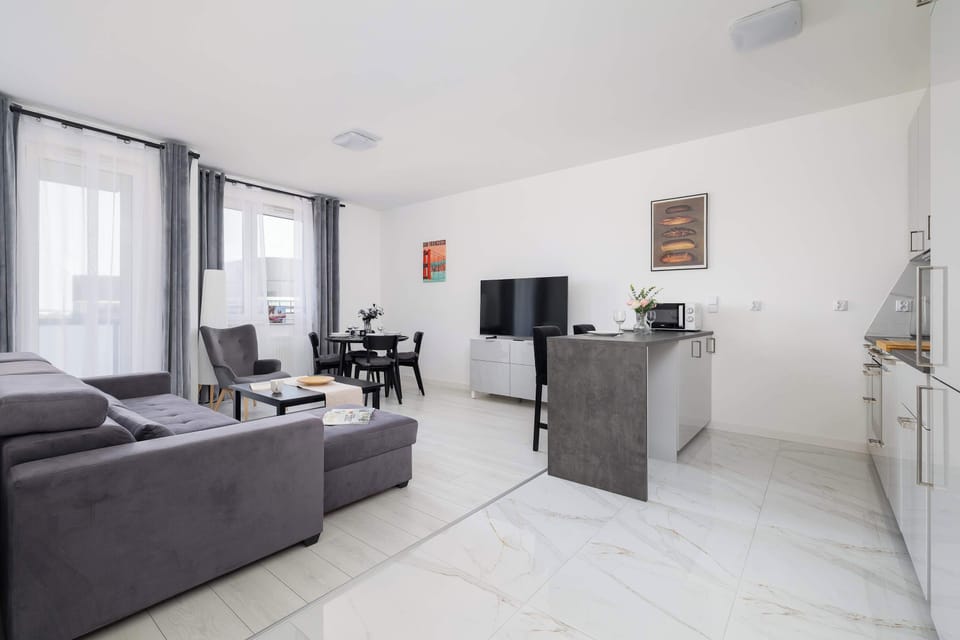 Spacious living area with a fold-out sofa, TV, kitchenette and dining area.