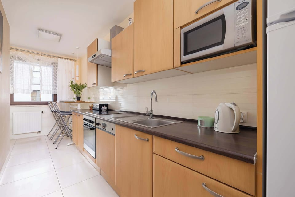 Dining area and fully equipped kitchen with electric cooktop.