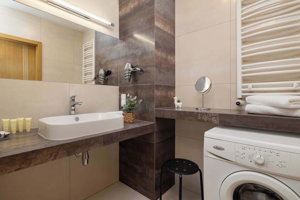 Bathroom with a sink, mirror and washing machine.