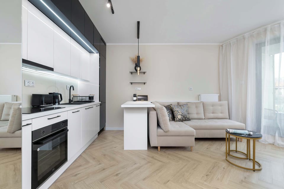 A stylish open-plan layout combining a kitchen, dining area, and living room with coordinated decor.