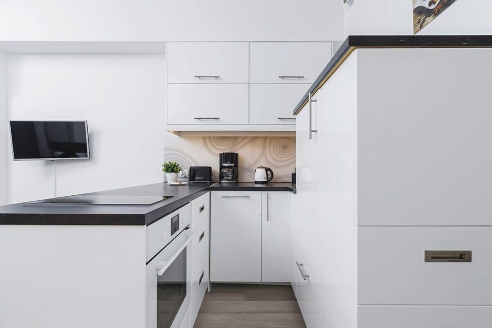 A corner of the kitchen with an integrated stove and black countertop, emphasizing clean, sharp lines.