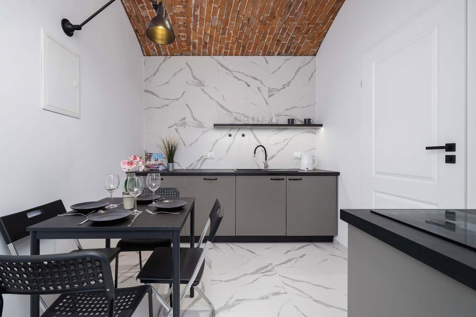 The small table and brick wall create an intimate space for meals or focused work.