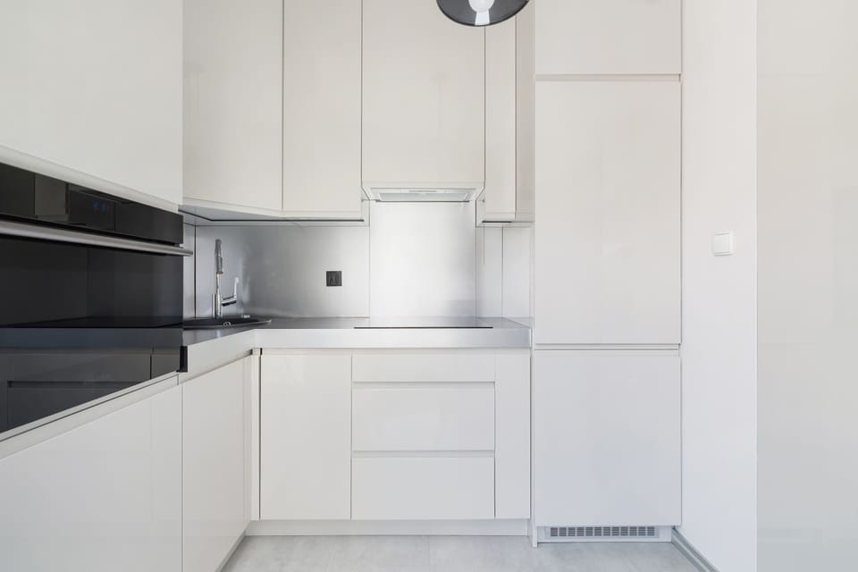 A bright kitchen with contrasting fronts and integrated appliances combines aesthetics with functionality.