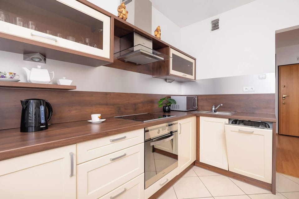 Another view of a kitchen with a dark wood and cream color scheme, featuring a stove and ample counter space.