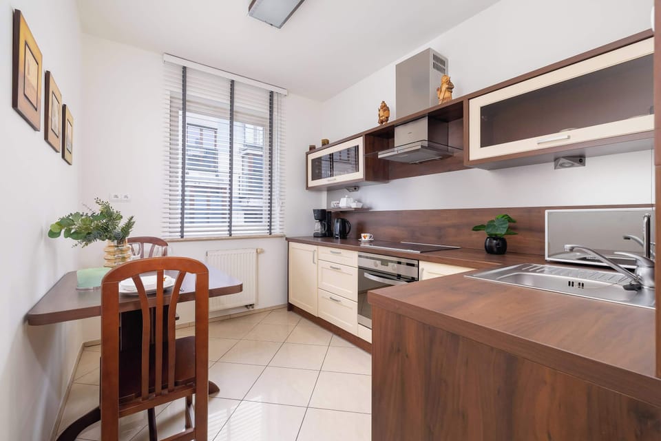 A small dining area with a wooden table, chairs, and a window providing natural light.