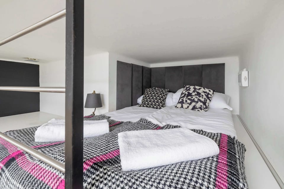 A cozy sleeping space on the mezzanine, with a large bed and soft bedding for a comfortable rest.