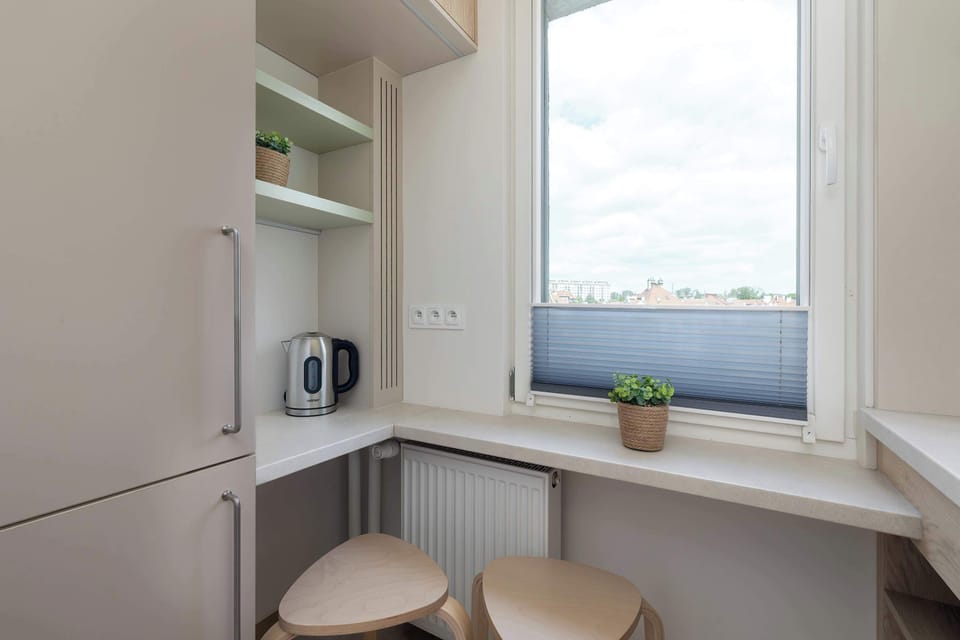 Compact and modern kitchen with wood cabinetry and integrated appliances.