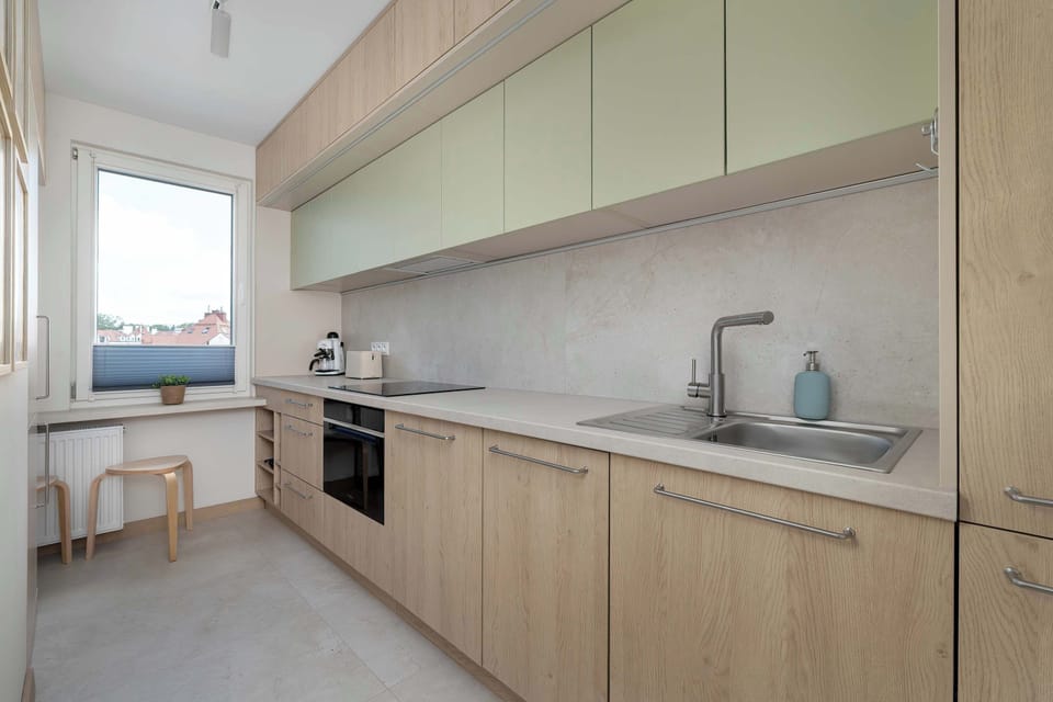 Compact and modern kitchen with wood cabinetry and integrated appliances.