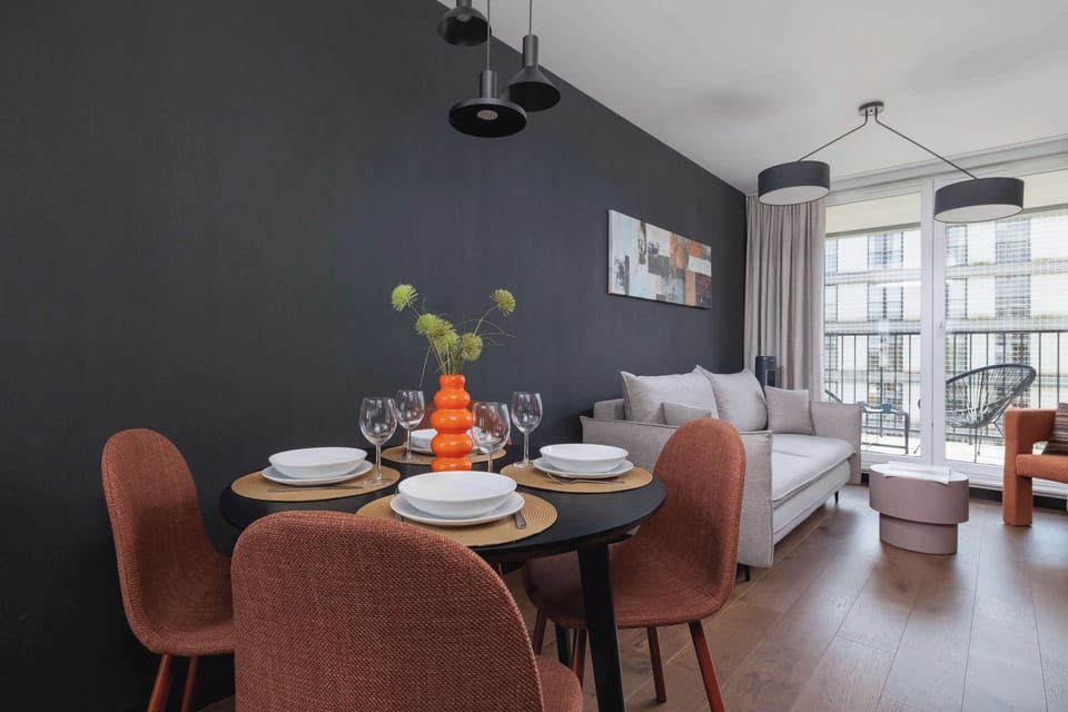 Dining area and stylish living room with sofa and Smart TV.