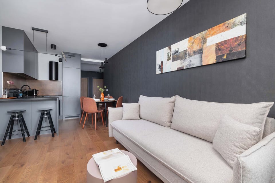 Living room with a sofa bed, Smart TV and kitchenette with dining area.