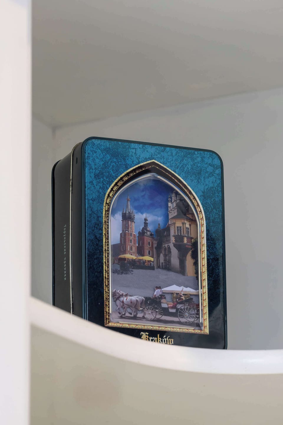 A small shelf featuring neatly arranged books and decor items like a framed picture.