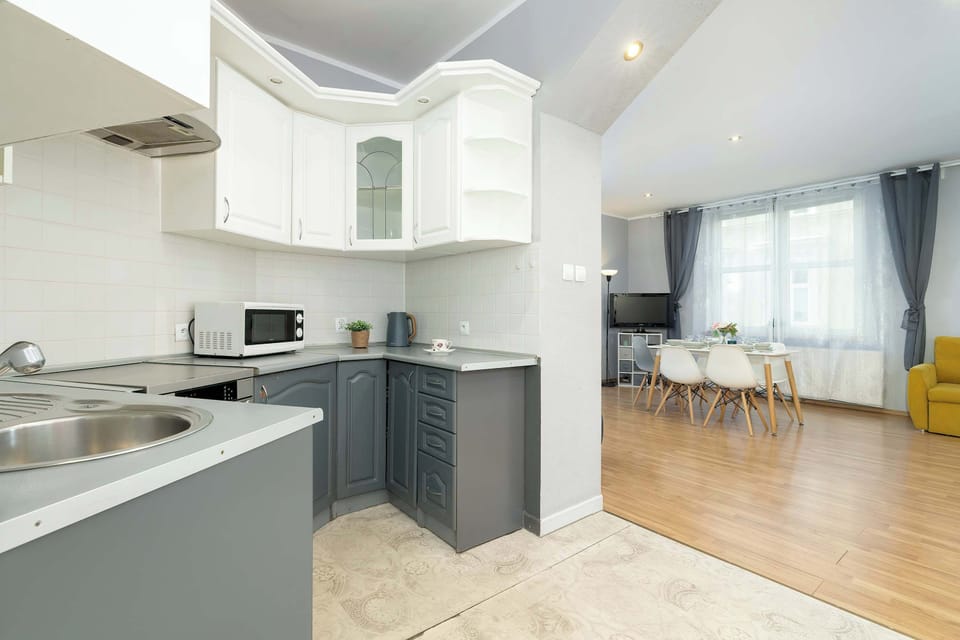 A detailed view of the kitchen showcasing the white cabinets, gray drawers, and sleek countertops.