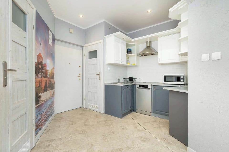A detailed view of the kitchen showcasing the white cabinets, gray drawers, and sleek countertops.