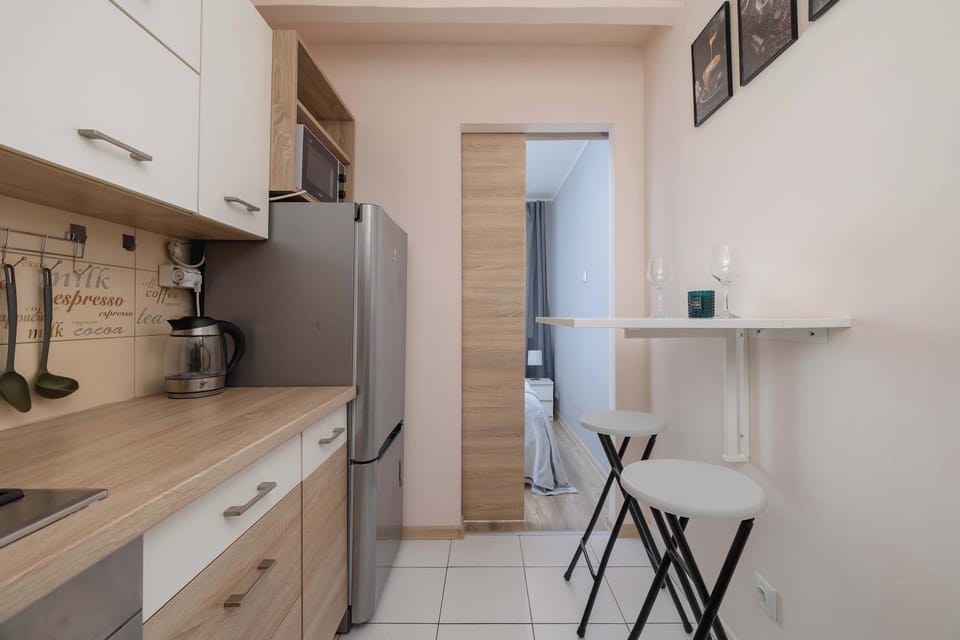 Bright kitchen with beige and wooden colors and a table for two.