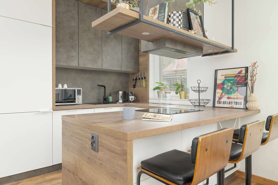Fully equipped kitchenette with induction cooktop, oven, microwave, refrigerator with freezer, dishwasher and dining area.