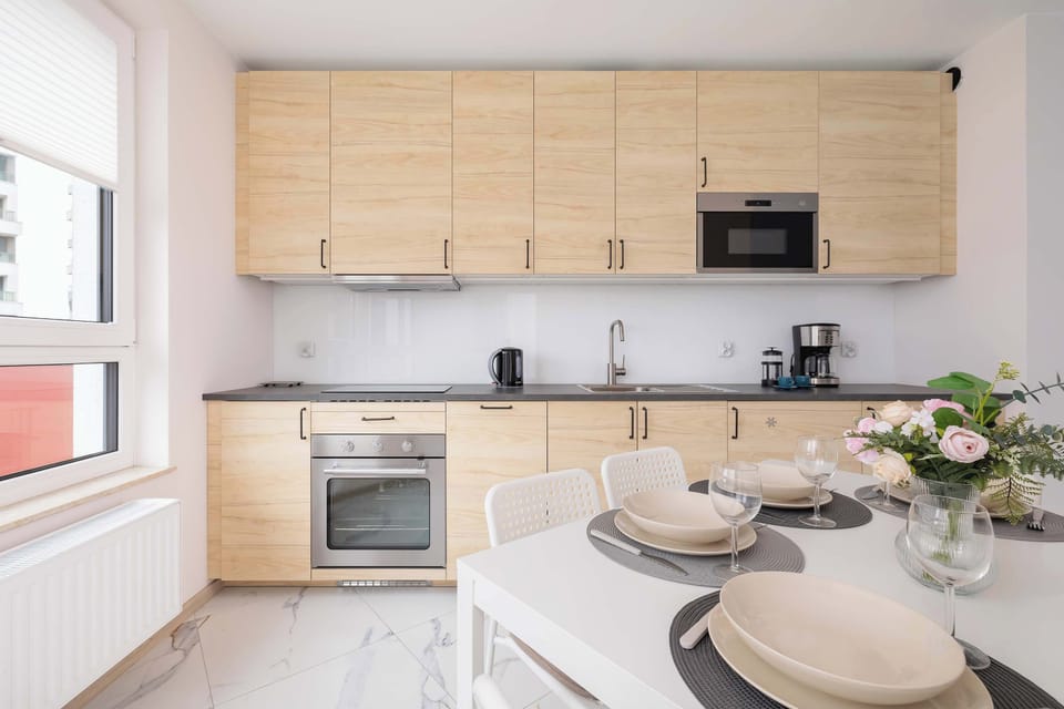 Functional and bright kitchenette with a microwave, an oven, an electric kettle, and a transfer coffee maker.
