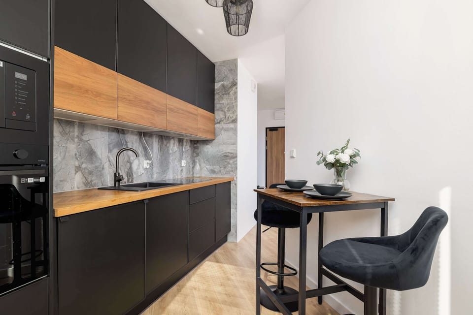 Stylish kitchen with dining table, separated by a wall from the rest of the room. 