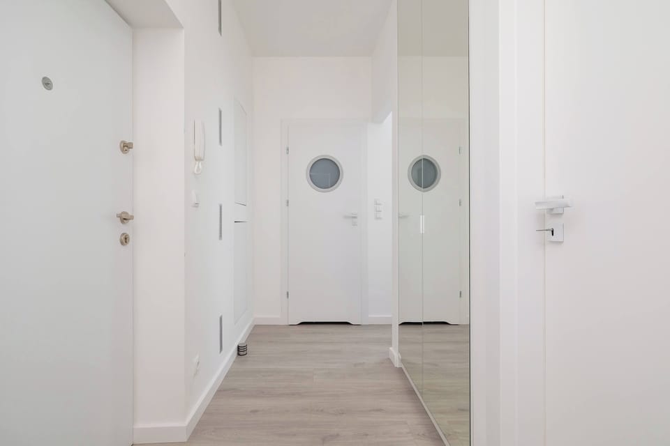 A bright hallway with mirrored doors and wooden flooring creates a pleasant first impression upon entering the apartment.
