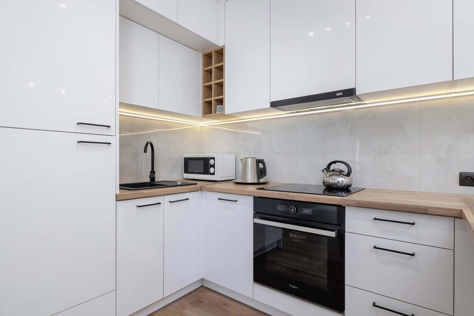 Clean white cabinetry with under-cabinet lighting gives the kitchen a sleek, modern touch.

