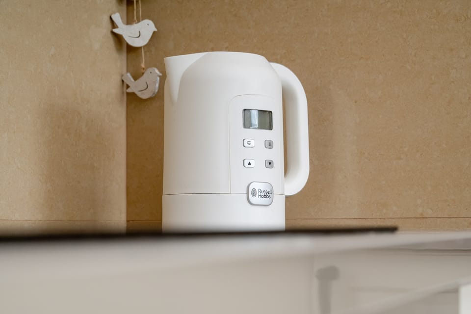 An electric kettle within reach offers quick access to hot drinks at any time.